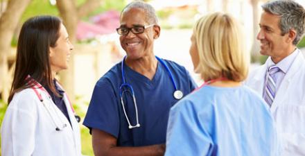 Doctors talk during a meeting outside. 