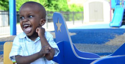 An excited child playing on a playground.