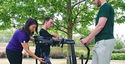 A patient receives therapy on a stander in Kennedy Krieger's Therapy Garden.