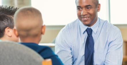 A therapist speaks to two boys.