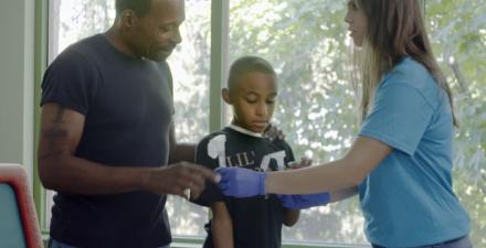 A father and son meet with a female member of SPARK's team.