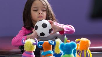 Sanayah holds a toy soccer ball