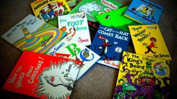 An assortment of Dr. Seuss books sit atop a carpet
