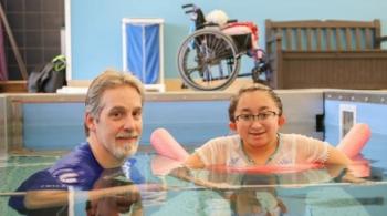 A photo of Shannon in an aquatic therapy pool with her physical therapist, Chris Joseph