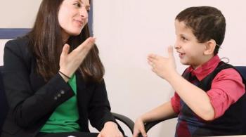 A therapist communicates with a hard of hearing patient using American Sign Language