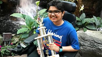 A photo of Kennedy Krieger patient Yuva holding a trophy