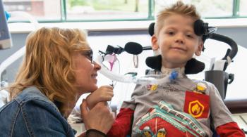 A photo of Geuoko at the International Center for Spinal Cord Injury. Sitting next to him is Dr. Cristina Sadowsky.