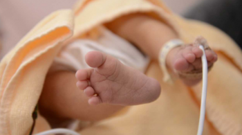 A photo of a baby's feet, in a hospital gown