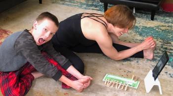 Noah looks at the camera as he and his mom, Tracy, do yoga via Zoom