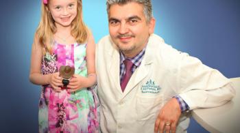 Ellie stands left, next to Dr. Ali Fatemi. Dr. Fatemi is kneeling to be in the frame with Ellie.
