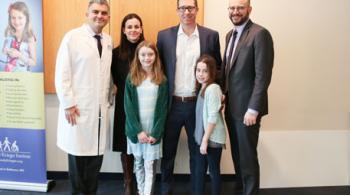 Dr. Brad Schlaggar and Dr. Ali Fatemi with a family (the McGinns).