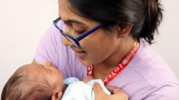 A mother cradles her infant.