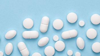 White medical pills lay scattered against a blue background.
