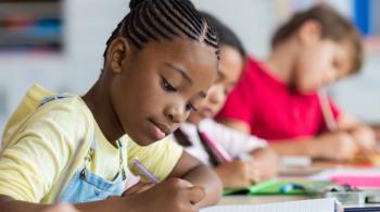 Children writing notes in classroom