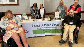People on the Go Maryland team surrounds the POG exhibitor table at The Arc Maryland State Convention.