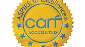 An icon shaped like an award seal that says: “Aspire to Excellence—CARF Accredited.”