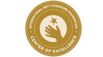  International Rett Syndrome Foundation (IRSF) Center of Excellence seal. The seal is gold, with an outline of a hand in the middle reaching for a star.