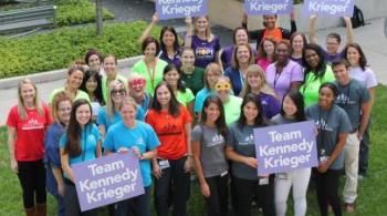 A group of Kennedy Krieger employees, wearing Kennedy Krieger shirts and holding signs that read, "Team Kennedy Krieger"