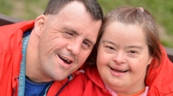 Two adults with Down syndrome wearing athletic apparel.