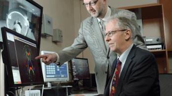 Drs. from the F.M. Kirby Center at Kennedy Krieger Institute look at data a monitor.