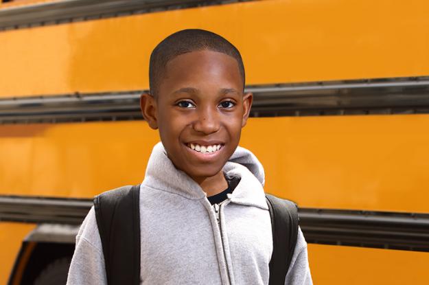 Mikey Standing in front of a school bus