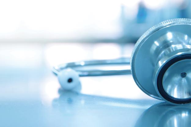 A stethoscope for sits on medical laboratory table. The background of the image is faded.