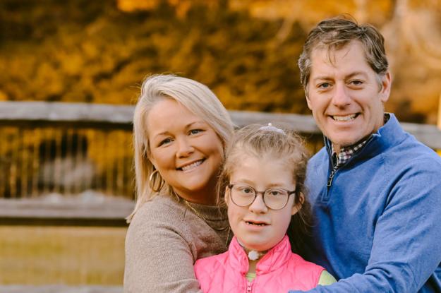 A Kennedy Krieger patient and her parents smile in their backyard.