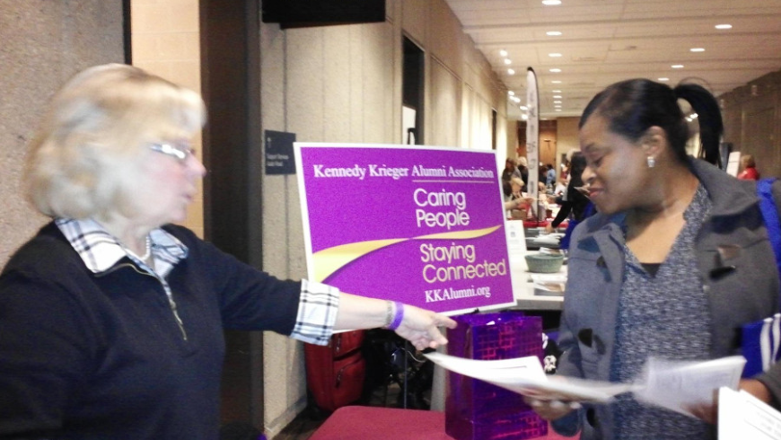 Two women speak at the Kennedy Krieger Alumni table during the benefits fair.