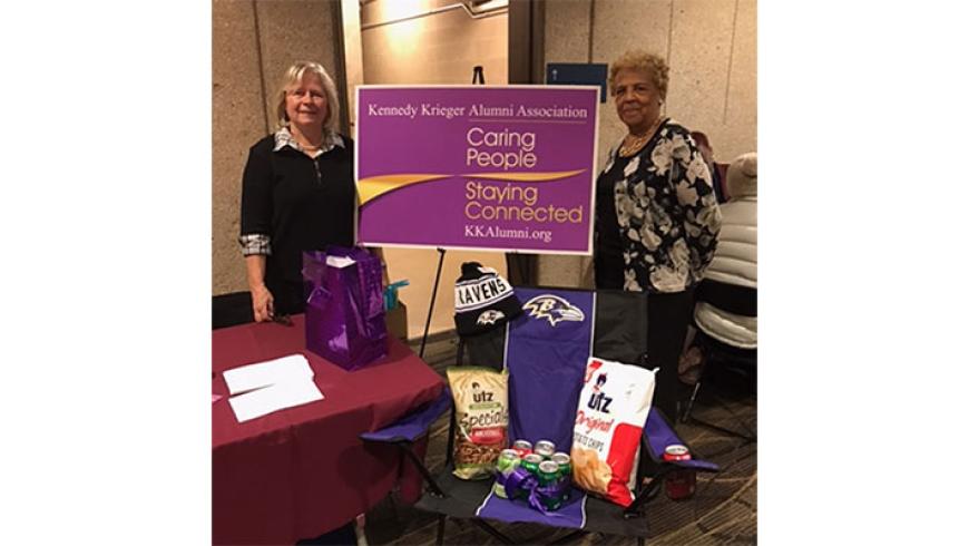 Two women pose for a photo at the Kennedy Krieger Alumni table. 