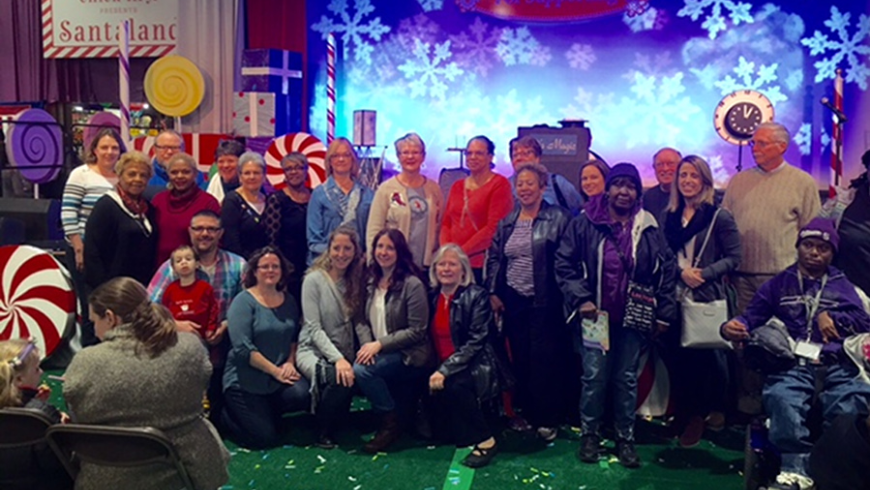 A group of alumni pose for a photo at Festival of Trees 