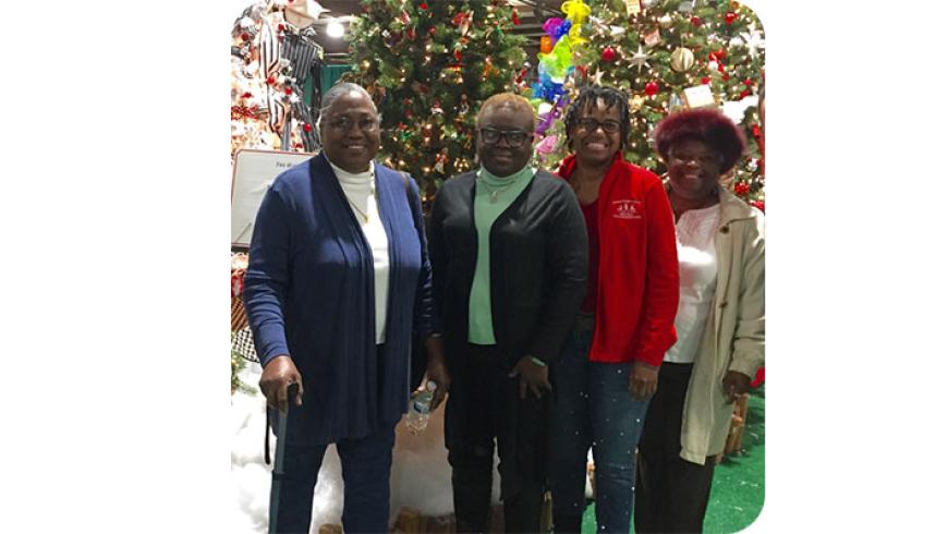 Four women pose for a photo at Festival of Trees.