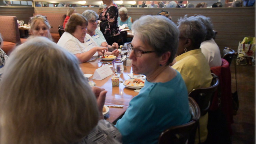 A table of attendees converse during the event. 