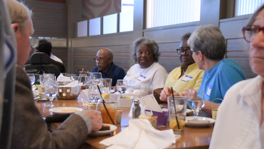 A table of attendees engage in conversation. 