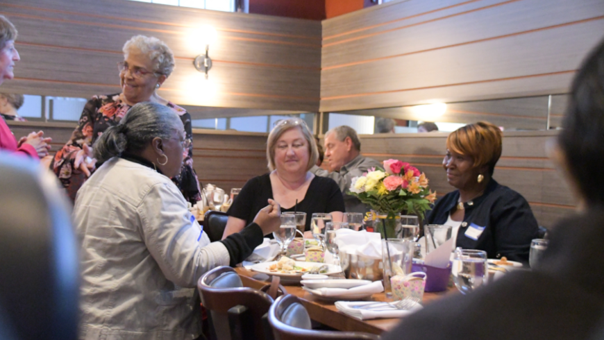 A table of attendees engage in conversation.