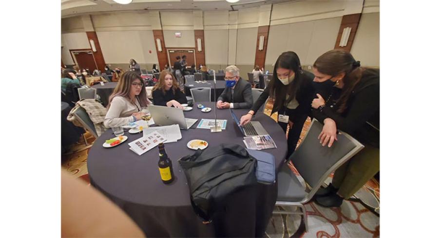 Members of the Opendak Lab team sit around a table during a conference. 