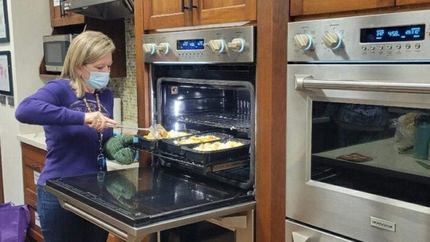 A nurse removes food from a stove at Ronald McDonald House.