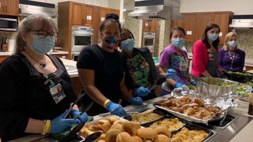 Side angle view of Kennedy Krieger nurses preparing food in the kitchen at Ronald McDonald house.