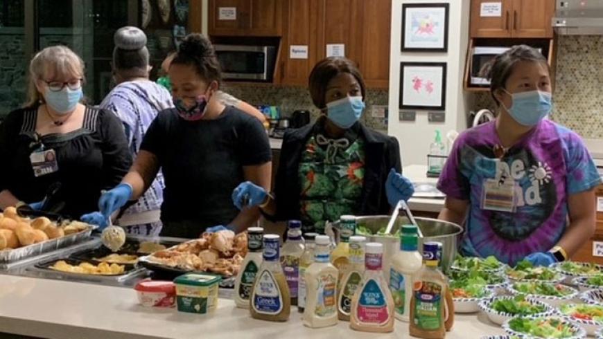 Front view of Kennedy Krieger nurses preparing food in the kitchen at Ronald McDonald house.