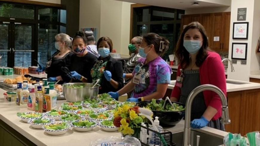 Side, long angle view from the right of Kennedy Krieger nurses preparing food in the kitchen at Ronald McDonald House.