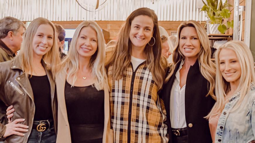 Five women pose for a photo inside of the taproom at Farmacy Brewing, the venue for Barrels & Bonfires. 
