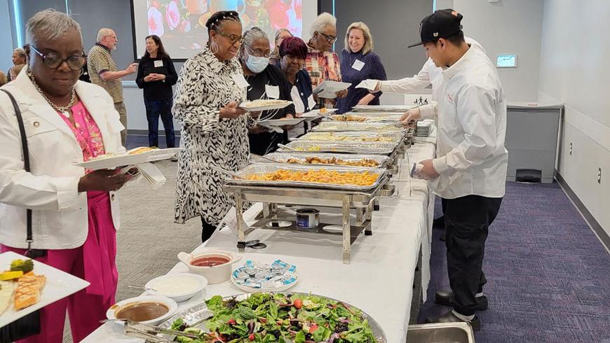 Attendees get lunch from a buffet. 