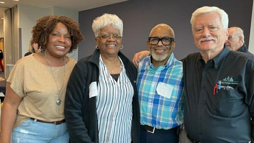 Four attendees, including two women and two men, stand next to each other.