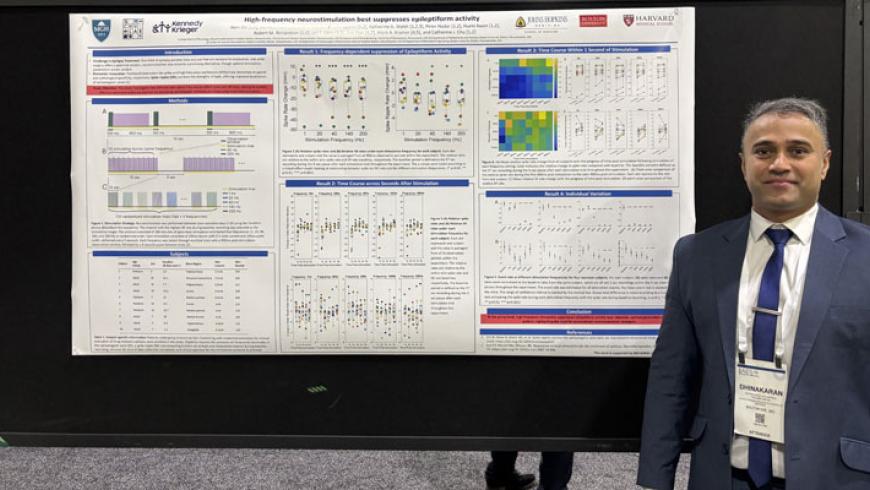 Dhina Chinappen’s stands in front of his research poster.