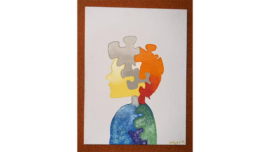 A watercolor silhouette of a person composed of multicolored jigsaw puzzle pieces.
