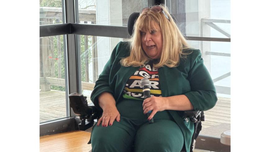 Tracy Wright speaks into a microphone during her presentation.