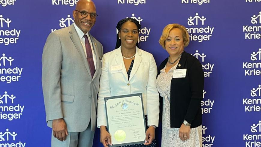 A man and woman present Dr. Mirian Ofonedu with a Maryland Governor's citation.