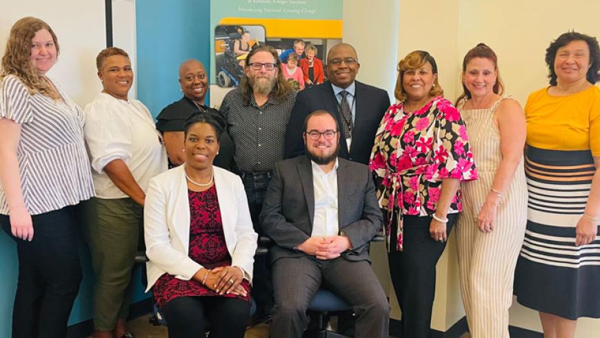 A group photo from the 2025 conference. Two people are seated in the front row, with eight standing in the back.