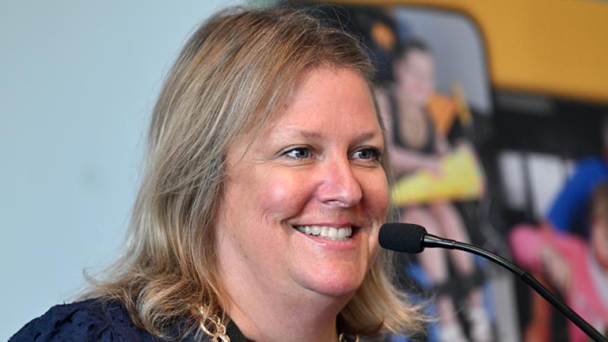 Maureen van Stone, avp of the Maryland Center for Developmental Disabilities, smiles while giving a speech at the podium.